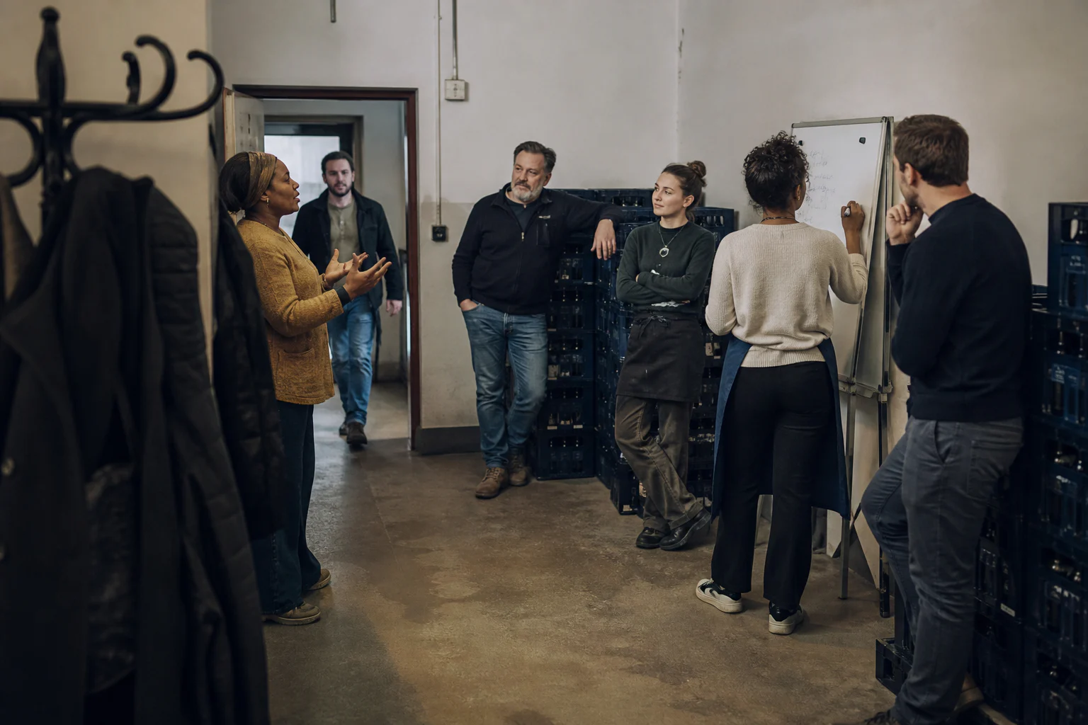 Multicultural team framing its priorities while standing in a small Belgian business