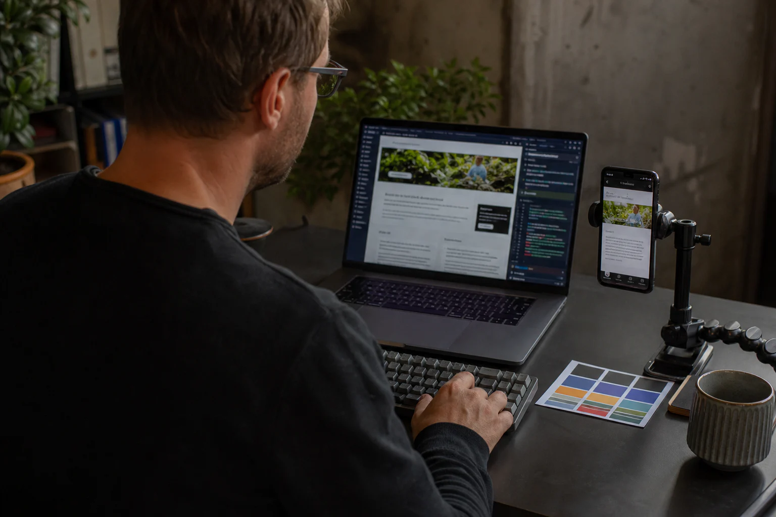 Consultant testing website quality on a computer and smartphone at his workstation