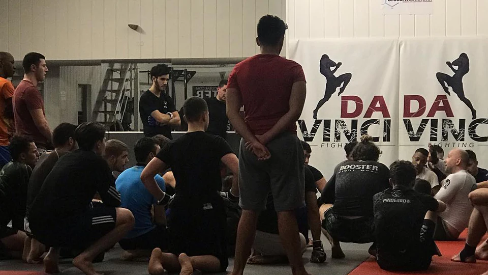 Davinci Fighting : briefing collectif sur les tatamis du club avant un entraînement de MMA à Bruxelles.